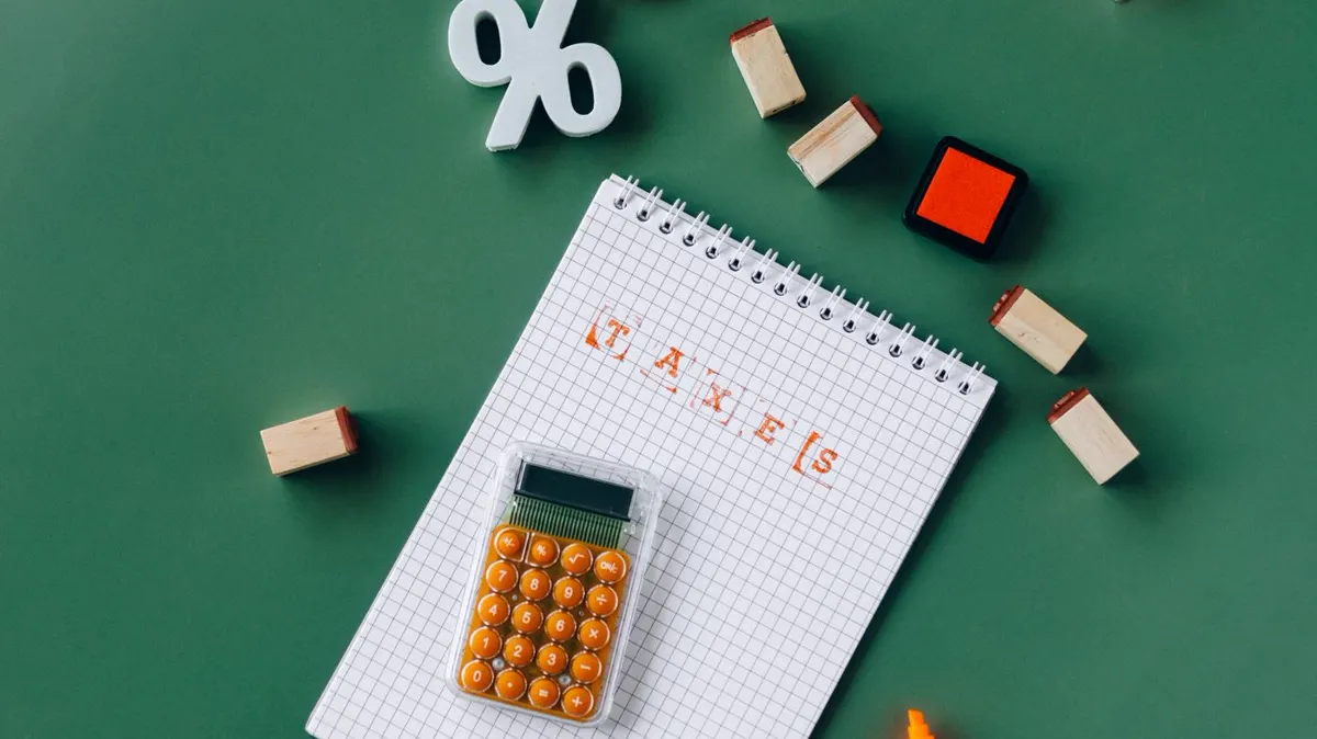 Tax paperwork, calculator and notebook on a desk